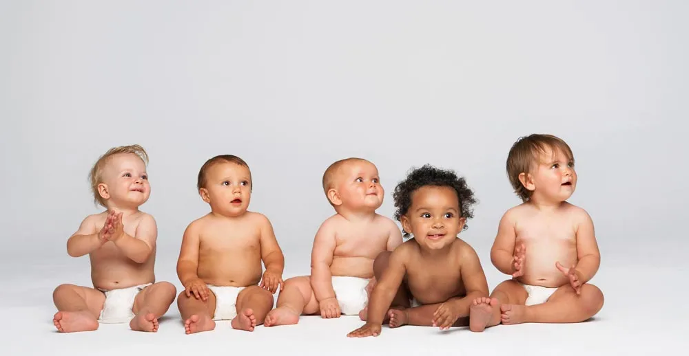 Fünf Babys sitzen nebeneinander